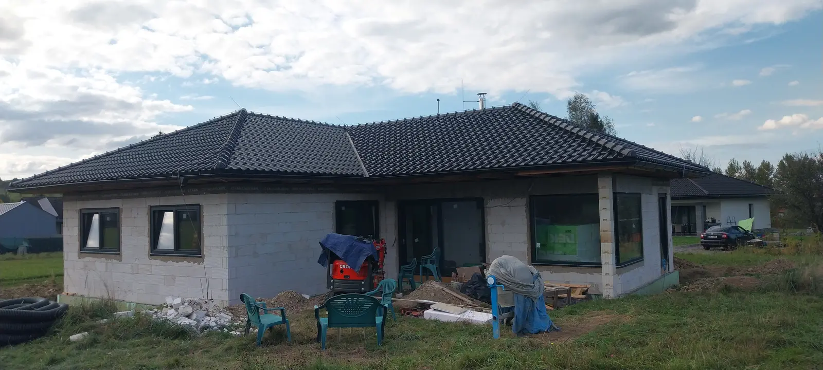 Nová valbová střecha s tmavou krytinou na bungalovu